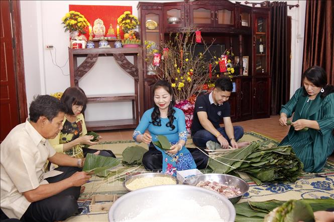 Trong ảnh: Bà Ma Thị Kim Cương cùng gia đình, bạn bè và con cháu đang cùng góp bánh chưng để ăn tết theo phong tục truyền thống của Việt Nam. Ảnh: Bá Thành - Phóng viên TTXVN tại Lào.