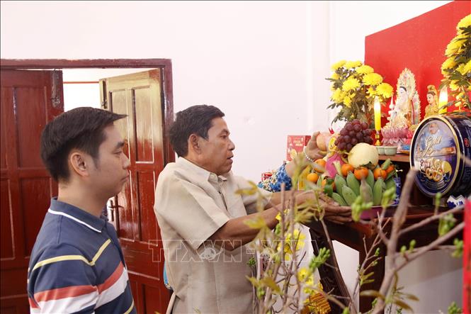 Trong ảnh: Ông Sithone Chanthavong chồng bà Cương đang bê mâm ngũ quả đặt lên ban thờ chuẩn bị đón Tết. Ảnh: Phạm Kiên - Phóng viên TTXVN tại Lào.