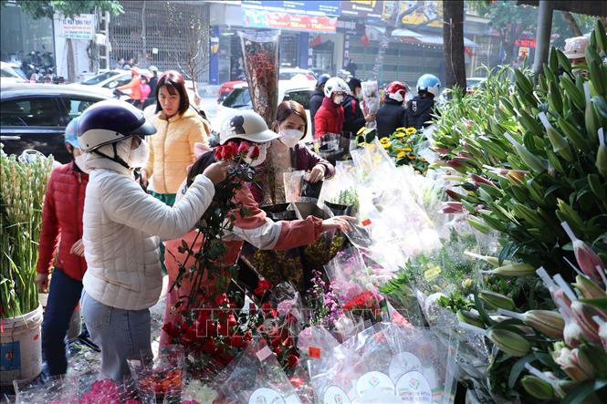 Trong ảnh: Người dân chọn mua hoa về chơi Tết tại khu vực chợ Rồng – thành phố Ninh Bình. Ảnh: Đức Phương - TTXVN
