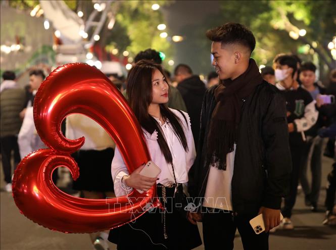 Trong ảnh: Hai bạn trẻ đi chơi tại Khu vực phố đi bộ Hồ Gươm đêm 30 Tết. Ảnh: Hoàng Hiếu - TTXVN 