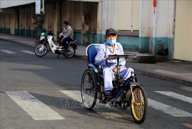 Một người khuyết tật bán vé số trên đường Phan Chu Trinh, phường Bến Thành, Quận 1, sáng mùng 1 Tết. Ảnh: Hồng Đạt - TTXVN
