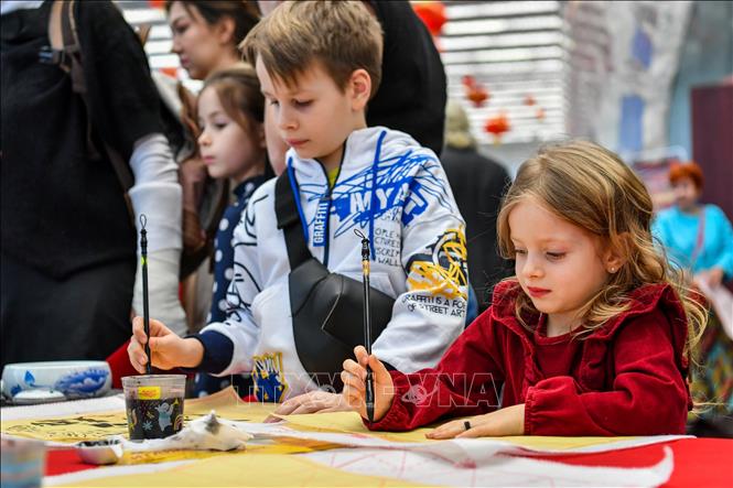 Tập viết thư pháp tại hoạt động mừng Năm mới Quý Mão 2023 của cộng đồng người châu Á ở Moscow, Nga ngày 21/1/2023. Ảnh: THX/TTXVN