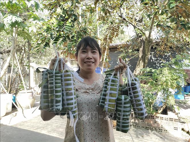 Từ bàn tay khéo léo, những đòn bánh tét đậm vị truyền thống đã hoàn thành để dâng lên tổ tiên. Ảnh: Huỳnh Phúc Hậu - TTXVN