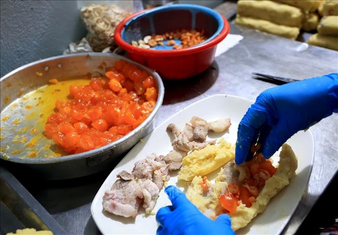Banh tet's fillings include salted eggs, cashew nuts, meat and green beans. VNA Photo: Hồng Đạt