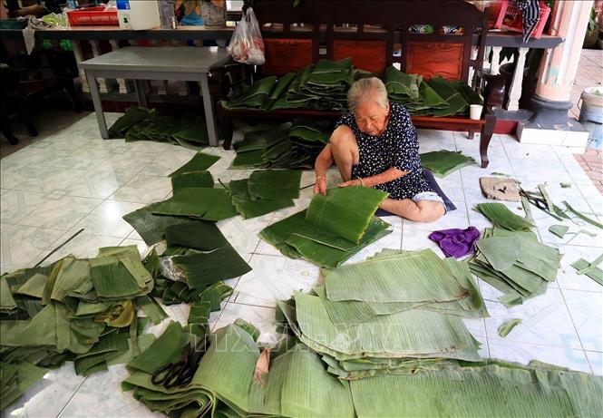Mrs. Nguyen Thi Ich (82 years old) is cleaning the banana leaves to wrap the cake. VNA Photo: Hồng Đạt