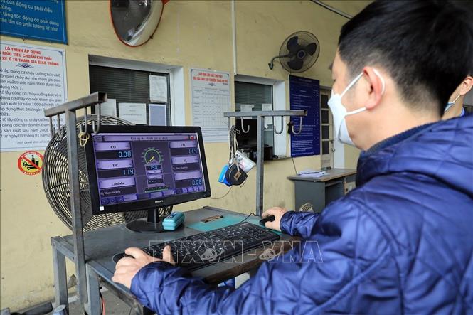 Cán bộ Trung tâm đăng kiểm xe cơ giới số 29.03V kiểm tra khí thải động cơ trên hệ thống của các phương tiện. Ảnh: Tuấn Anh - TTXVN