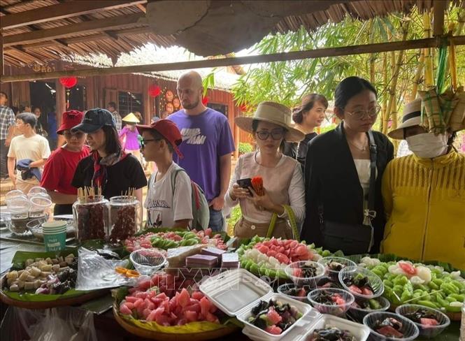 Du khách trong và ngoài nước thưởng thức các món bánh dân gian Nam Bộ tại khu du lịch Cồn Phụng (huyện Châu Thành, Bến Tre). Ảnh: Chương Đài - TTXVN 