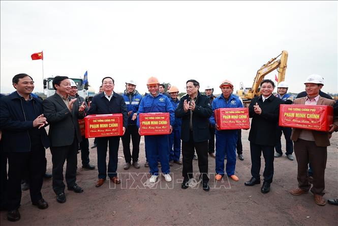 Thủ tướng Phạm Minh Chính động tặng quà cho kỹ sư, công nhân thi công dự án cao tốc Bãi Vọt - Hàm Nghi. Ảnh: Dương Giang-TTXVN
