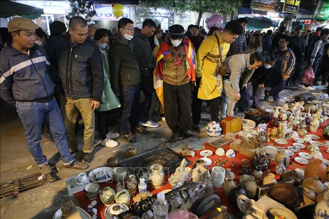 Gian hàng đồ gốm, đồ giả cổ tại chợ Viềng nhận được sự quan tâm của nhiều du khách. Ảnh: Công Luật - TTXVN
