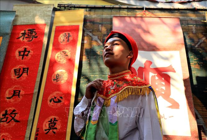 Dự hội có màn múa do trai làng đóng giả gái, má phấn, môi son, đầu chít khăn mỏ quạ. Ảnh: Nhật Anh - TTXVN