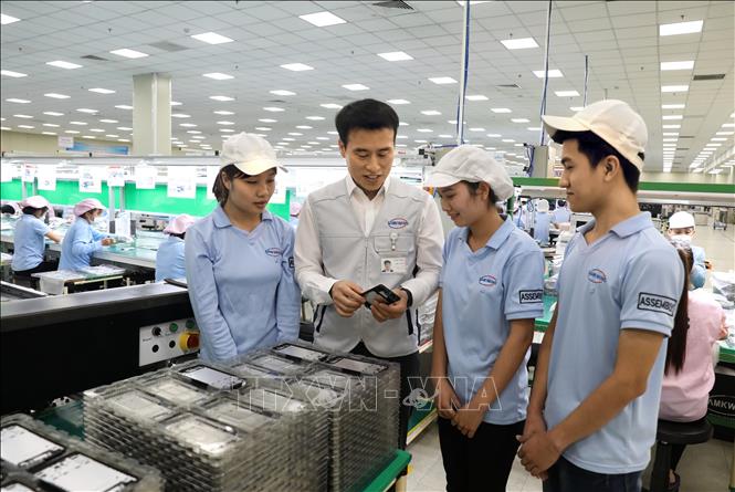 General Director Song Jongdeuk of the Korean-invested Samkwang Vina Co. Ltd at the Quang Chau IP, the northern province of Bac Giang, exchanges views with his Vietnamese workers. VNA Photo: Danh Lam