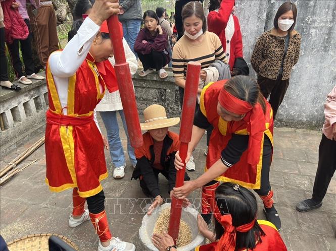 Trong khi đàn ông kéo lửa, thì phụ nữ cũng tất bật thi nhau giã gạo. Ảnh: Trung Kiên - TTXVN