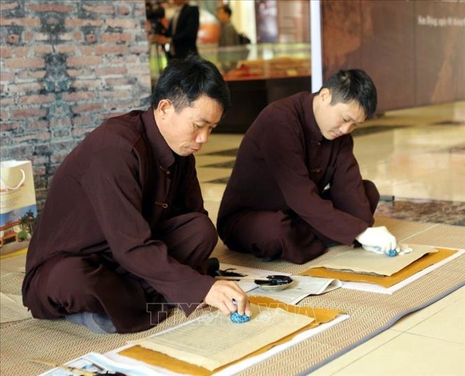 Woodblock printing techniques are introduced during the exhibition. VNA Photo: Đồng Thúy