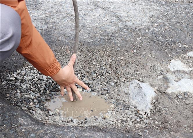 Tuyến Quốc lộ 1 qua địa bàn phường Phổ Thạnh, thị xã Đức Phổ, tỉnh Quảng Ngãi xuất hiện nhiều ổ gà còn đọng nước gây nguy cơ mất an toàn giao thông. Ảnh: Phạm Cường-TTXVN
