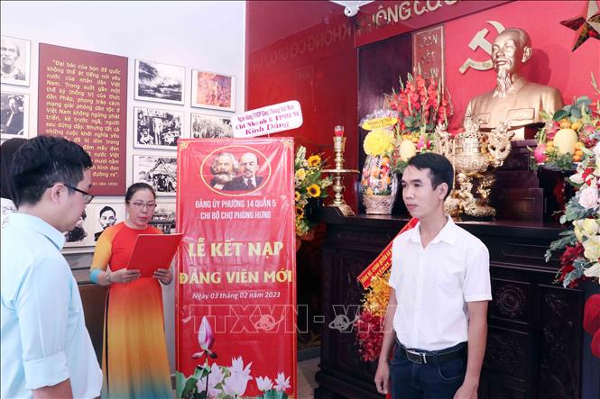 Trong ảnh: Ông Trần Phi Đạo (sinh năm 1985), Ban Quản lý chợ Phùng Hưng, phường 14, Quận 5, trang nghiêm nghe đọc quyết định kết nạp đảng viên tại Khu du lích lưu niệm Hồ Chí Minh tại Thành phố Hồ Chí Minh. Ảnh: Xuân Khu-TTXVN