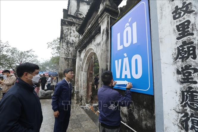 Ban tổ chức dán biển chỉ dẫn cho người dân và du khách thập phương đến lễ hội. Ảnh: Minh Quyết - TTXVN