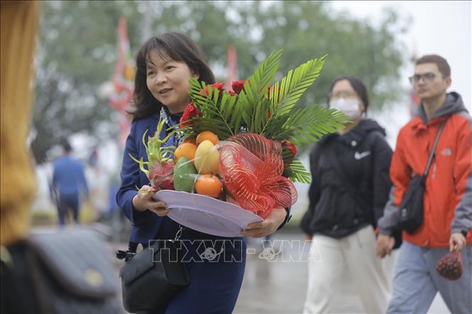 Người dân địa phương và du khách sắp lễ đến đền Trần từ sáng sớm ngày 4/2 để cầu một năm mới sức khoẻ, an khang và hạnh phúc. Ảnh: Minh Quyết - TTXVN