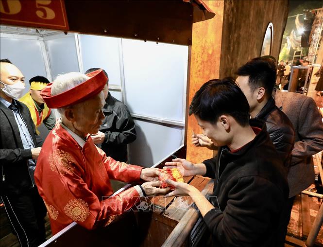 Túi lương được phát cho người dân và du khách dự lễ tại 19 cửa bố trí quanh đền Trần Thương. Ảnh: Nhật Anh - TTXVN