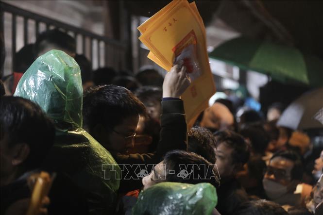 Đúng 5h sáng 5/2/2023 (15 tháng Giêng), Ban tổ chức lễ hội bắt đầu phát lộc ấn cho người dân và du khách. Ảnh: Minh Quyết - TTXVN