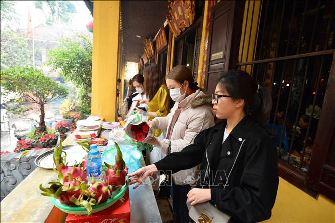 Trong ảnh: Người dân sửa soạn mâm lễ cầu bình an, may mắn cho năm mới. Ảnh: Minh Đức – TTXVN