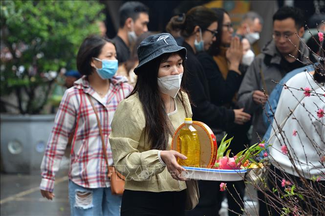 Trong ảnh: Người dân sửa soạn mâm lễ cầu bình an, may mắn cho năm mới. Ảnh: Minh Đức – TTXVN