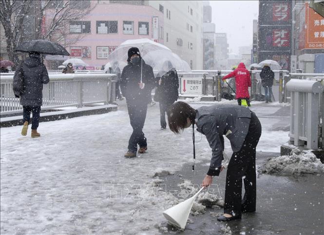 Người dân dọn tuyết trên đường phố tại Tokyo, Nhật Bản, ngày 10/2/2023. Ảnh: Kyodo/ TTXVN