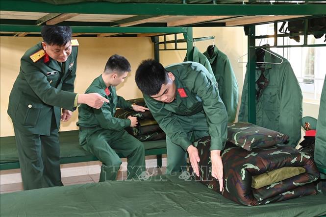 Trong ảnh: Trung đội trưởng hướng dẫn nội vụ như gấp chăn màn... Ảnh: Thanh Vân-TTXVN

