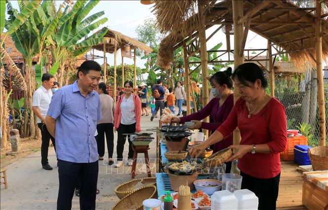 Chủ tịch UBND tỉnh Đồng Tháp Phạm Thiện Nghĩa tham quan, hỏi thăm tình hình kinh doanh của người dân tại chợ quê cồn Tân Thuận Đông. Ảnh: Nhựt An - TTXVN