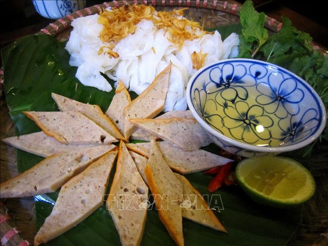 Banh cuon could be eaten with cha que (orange-hued, roasted cinnamon sausage) or cha lua (Vietnamese classic silky sausages) to boost their taste. VNA Photo: Phạm Hậu