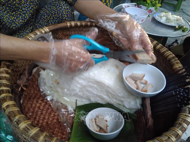 Banh cuon from Hanoi's Thanh Tri suburd district is paper thin and look almost transparent, having no stuffing but being served with cha que (orange-hued, roasted cinnamon sausage). VNA Photo: Phạm Hậu 