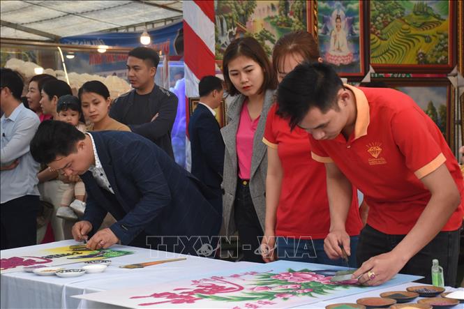 Trong ảnh: Các nghệ nhân tham gia Hội thi chế tác tranh đá quý tại phiên chợ. Ảnh: Tuấn Anh - TTXVN 