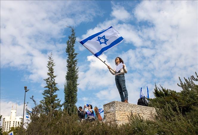 Một người biểu tình giương cờ Israel. Ảnh: Vũ Hội - P/v TTXVN tại Israel