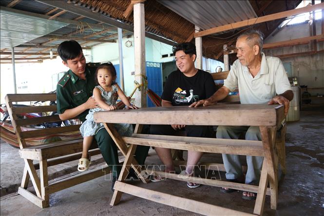 Ông Nguyễn Bá Cường (áo trắng, bìa phải), là một trong những người đầu tiên được di dân theo Đề án 407 đã có cuộc sống ổn định qua 3 thế hệ. Ảnh: Thanh Tân - TTXVN

