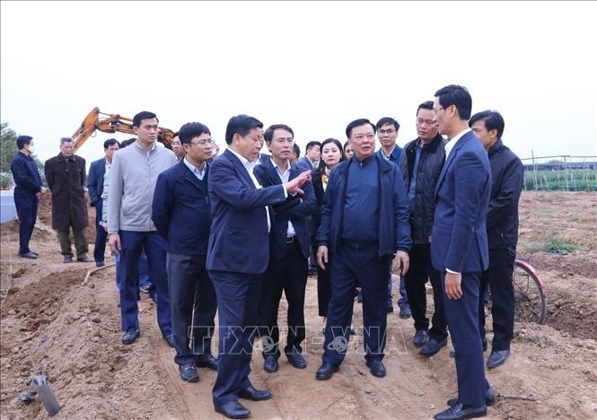 Bí thư Thành ủy Hà Nội Đinh Tiến Dũng kiểm tra thực địa tại địa điểm quy tập mộ tại nghĩa trang xã Hồng Hà, huyện Đan Phượng. Ảnh: Văn Điệp - TTXVN