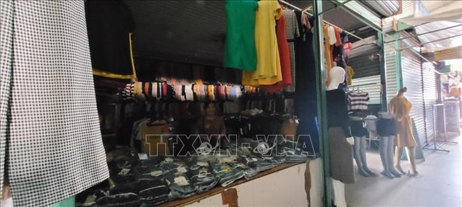 Trong ảnh: Các kiot nằm trong giữa chợ tối om do chợ bị ngưng cấp điện. Ảnh: Hoàng Nhị - TTXVN.