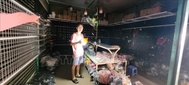 Trong ảnh: Chợ Tân Thành bị ngưng cấp điện, tiểu thương phải dùng tích điện để bán hàng. Việc ngưng cấp điện là do yêu cầu tư phía chủ đầu tư  để yêu cầu bà con di dời ra khỏi chợ để họ cải tạo lại chợ. Ảnh: Hoàng Nhị - TTXVN./.