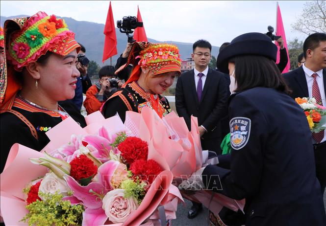 Trong ảnh: Phía Trung Quốc tặng hoa cho cho người dân Việt Nam xuất cảnh tại khu vực cửa khẩu quốc tế Ma Lù Thàng (Lai Châu, Việt Nam) -  Kim Thủy Hà (Trung Quốc). Ảnh: Nguyễn Oanh-TTXVN.
