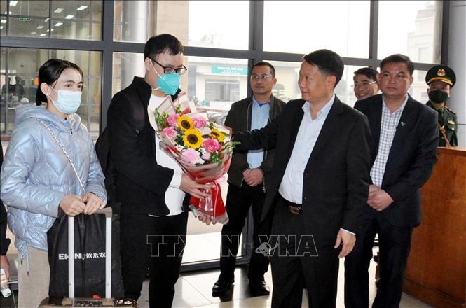 Local authorities of Mong Cai city present flowers to first citizens of the two countries exiting and entering Vietnam via the Mong Cai Gate. Photo by courtesy/VNA 