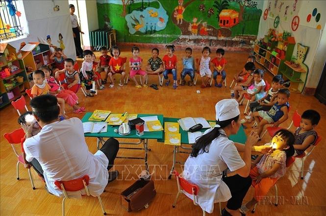Nhân viên Trung tâm y tế huyện Nho Quan (Ninh Bình) kiểm tra sức khỏe để tổ chức tiêm chủng cho trẻ. Ảnh: Minh Đức - TTXVN