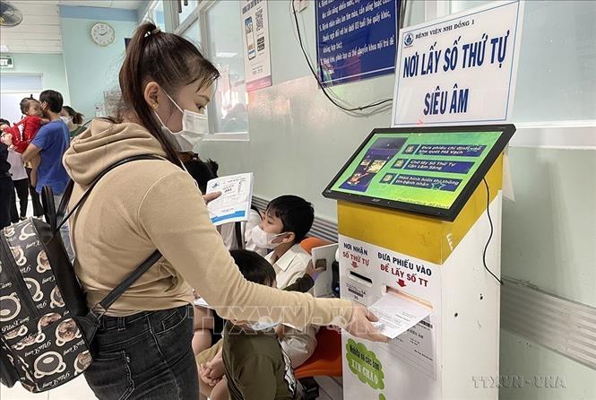 Những năm qua, nhiều đơn vị y tế tại thành phố Hồ Chí Minh đã thực hiện chuyển đổi số, sử dụng ứng dụng công nghệ thông tin trong quản lý, điều hành và phục vụ người bệnh. Trong ảnh: Người dân tự lấy số thứ tự khi đi khám tại Bệnh viện Nhi đồng 1 Thành phố Hồ Chí Minh (11/2022). Ảnh: Đinh Hằng – TTXVN