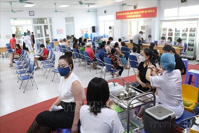 Để nhanh chóng bao phủ vaccine phòng COVID-19, hạn chế sự lây lan của dịch, các trung tâm y tế quận trên địa bàn Hà Nội tăng cường công tác tiêm vaccine phòng COVID-19, nhất là mũi 3, mũi 4 cho người dân (8/2022). Ảnh: Minh Quyết - TTXVN