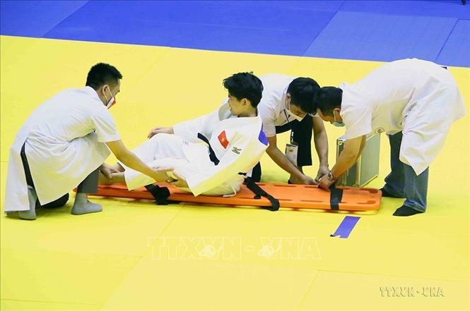 Các nhân viên y tế chăm sóc VĐV Karate Trần Lê Phương Nga gặp chấn thương nặng trong thi đấu ở SEA Games 31 (18/5/2022). Ảnh: Quang Quyết-TTXVN
