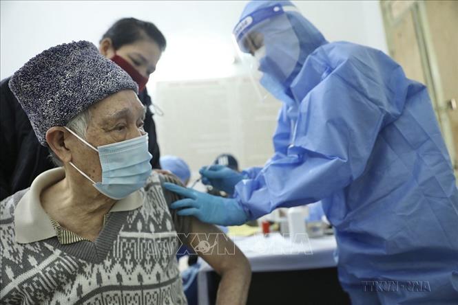 Nhân viên Trạm y tế phường Hàng Bông, quận Hoàn Kiếm (Hà Nội) tiêm chủng vaccine phòng COVID-19 cho nhóm người trên 50 tuổi, người có bệnh lý nền, người chưa tiêm đủ vacvine… nhằm giảm tỷ lên chuyển nặng, tỷ lệ tử vong, bảo vệ cho người dân (2/2022). Ảnh: Minh Quyết - TTXVN