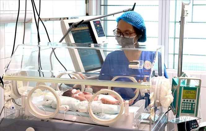 Bác sĩ Bệnh viện Sản Nhi tỉnh Bắc Ninh chăm sóc cặp song sinh đầu tiên chào đời bằng phương pháp thụ tinh ống nghiệm (12/2021). Ảnh: Đinh Văn Nhiều-TTXVN