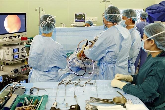 Chuyên gia Pháp cùng các bác sĩ, kỹ thuật viên khoa Chấn thương chỉnh hình và Cột sống - Bệnh viện Bạch Mai thực hiện các kỹ thuật hiện đại trong phẫu thuật nội soi tái tạo dây chằng khớp gối. Ảnh: Dương Ngọc - TTXVN