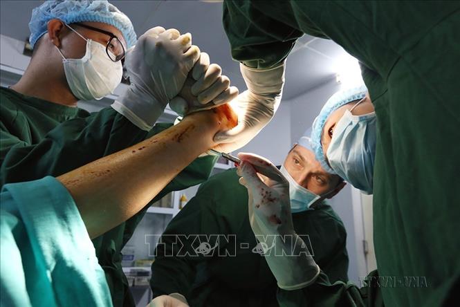 Chuyên gia Mỹ cùng với các bác sỹ của Bệnh viện chỉnh hình và phục hồi chức năng Hà Nội phẫu thuật cho bệnh nhân tàn tật. Ảnh: Anh Tuấn – TTXVN