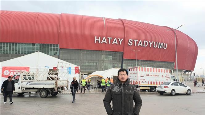 Sau lưng phóng viên, mái vòm sân vận động Hatay bị xô lệch sau động đất. Ảnh: TTXVN 