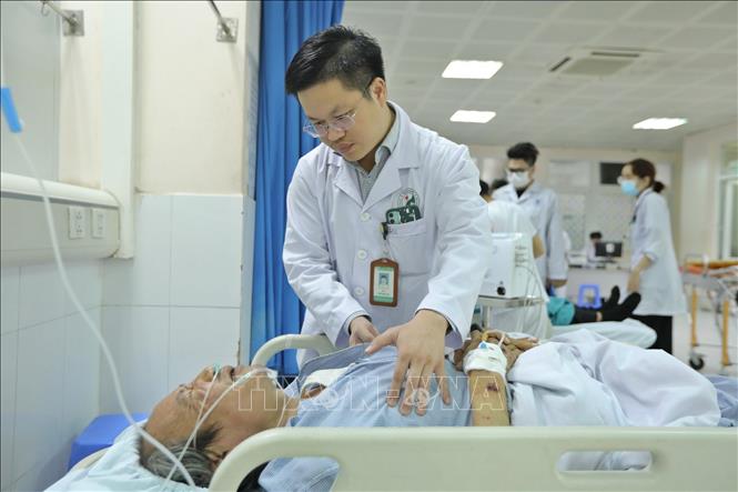 Bác sĩ Tân thăm hỏi các bệnh nhân tại khoa cấp cứu. Ảnh: Minh Quyết - TTXVN