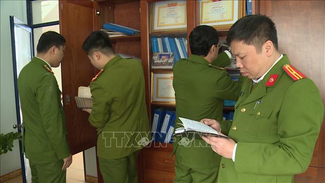 Lực lượng Công an thi hành lệnh khám xét nơi làm việc của các đối tượng tại Chi cục đăng kiểm số 11. Ảnh: TTXVN phát
 
