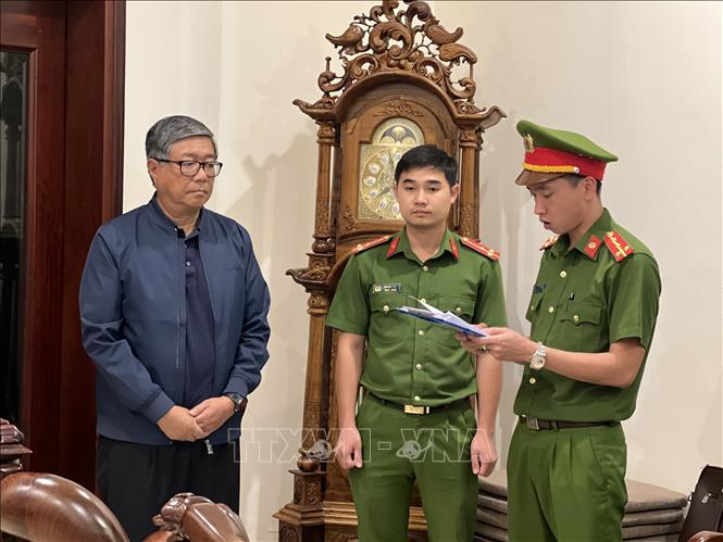 Cảnh sát điều tra Công an thành phố Đà Nẵng tống đạt các Quyết định khởi tố bị can, ra lệnh bắt tạm giam đối với ông Đoàn Quang Vinh nguyên Hiệu trưởng trường Đại học Bách Khoa Đà Nẵng. Ảnh: TTXVN phát